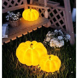 Glowing pumpkins on garden swing with flowers.
