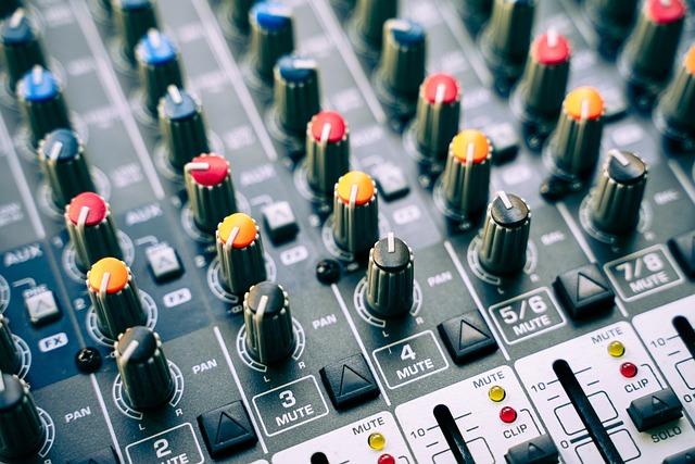 Audio mixing console with many knobs and sliders