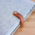 Gray laptop sleeve with brown leather clasp